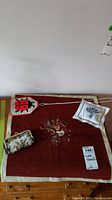 Lot overview showing the red cross stitch table decor, lavender sachet pillow, tapestry coin purse, and ladybug bug swatter