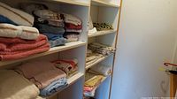 Shelved towels and folded linens in neutral and pastel tones
