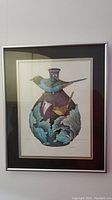 Framed print showing a blue and brown bird perched on a purple vase with blue-green leaves