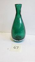 Front side view of the green hand blown control bubble vase showing its shape and bubble pattern.