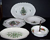 Five Christmas-themed dishes arranged against black background showing platter, vegetable bowl, plate, Bless This Home dish, and two-tier serving tray.