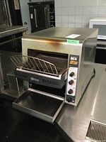 Front and right-side view of Holman commercial toaster with wire rack loaded and crumb tray extended.