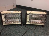 Two Creative brand electric space heaters model QH-1500 placed side by side showing full front and top views with power cords and metal protective grills.