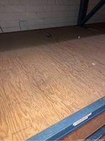 Plywood panel close-up showing wood grain texture on shelf.