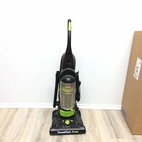 Front view of Bissell PowerForce Turbo upright vacuum cleaner showing base, dust canister, and attached hose and power cord.