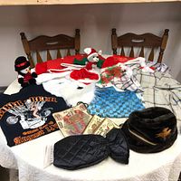 Full collection showing vintage men's clothing and accessories, Christmas hats and plush toys, t-shirt, swim trunks, Egyptian-themed bags, and fur hat.