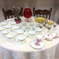 Overview of the entire collection spread on a white tablecloth with wooden chairs in the background.