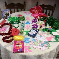 Full view of the table displaying assorted holiday decorations and games including St. Patrick's Day, Easter, Valentine's Day items in various colors and materials.