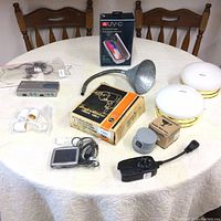 Full view of collection on table showing UV-C phone sanitizer, gooseneck lamp, ceiling light fixtures, computer hub, music player, and other accessories.
