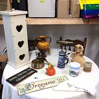 Photo showing the full collection on a white table including toilet paper holder, vase, signs, mouse figurine, beer stein, coasters, flower figurine, and a towel.
