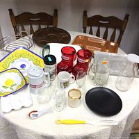 Overview of the assortment of glassware, ceramics, serving trays, and utensils on a round table.