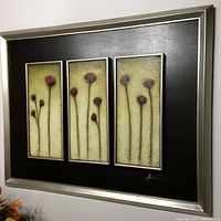 Front view of the oil painting showing the three panels of red poppies on beige textured background in a black matte and silver frame