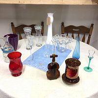 Overall group of various vases and glass decorative items arranged on a table showing all pieces for a comprehensive view.