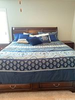 Front view of assembled sleigh bed frame with mattress and bedding