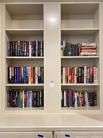 Wide view of six shelves filled with books of various genres including sports, thriller, fiction, and non-fiction.