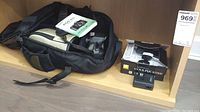 Canon backpack with EOS 40D manual inside, Nikon Coolpix S3300 box and charger on shelf