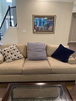 Front view of beige tweed sofa with three throw pillows