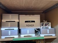 Five silver/white Sonos Connect:Amp units arranged on shelf