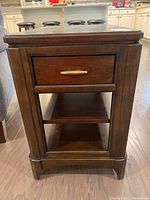 Side view of the wooden end table showing drawer, shelves, and dark brown finish.