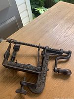 Photo of antique White Mountain apple peeler showing side with "WHITE MOUNTAIN APPLE" and "MADE BY GOODELL CO." markings