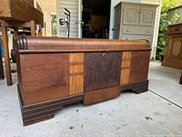 Front view of antique waterfall cedar chest showing wood grain, central darker panel, and two front drawers.