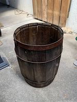 Side view of antique wooden nail keg barrel showing staves and metal hoops