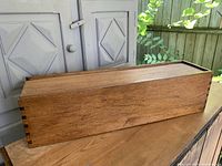 Full side view of vintage walnut map box featuring dovetailed joints and visible wood grain.
