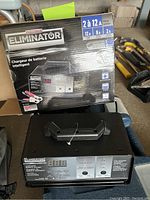 Eliminator intelligent car battery charger with its box showing product info and features.