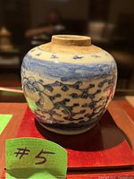 Side view of antique blue and white porcelain jar showing floral and sky motifs