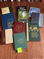 All ten atlases arranged on wooden floor with visible front covers.