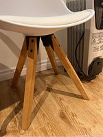Close-up of wooden legs showing natural wood finish and the structural design of the chair's base.
