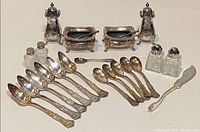 Full set displayed showing all pieces: salt and pepper shakers, salt cellars, six grapefruit spoons, 7-inch spreader.