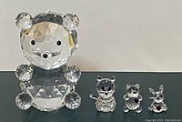 Front view of the large crystal teddy bear figurine with three smaller faceted animal figurines in front showing kitten, teddy bear, and bunny with red hearts