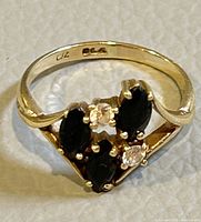 Close-up of ring face showing four marquise blue sapphires and two round diamonds