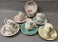 Six different English teacup and saucer sets arranged together to show variety of designs and colors.