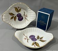 Two ceramic serving dishes with plum and leaf decoration, gold rim, arranged with Royal Worcester blue box