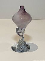 Front view of handmade blown glass decorative art piece showing the bulbous purple top and twisted clear stem with original label on base.