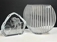 Two items side by side: vintage clear crystal paperweight with golfer design and a round modern striped glass vase.