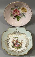 Two vintage hand painted porcelain bowls displayed side by side; round floral painted French bowl and square-shaped German Hutschenreuther bowl with gold detail and romantic scene