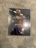 Front of signed boxing photo showing autograph in silver ink across the boxer's chest area.