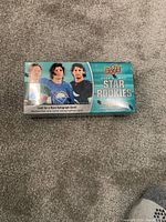 Sealed box of 2021-22 Upper Deck NHL Star Rookies hockey cards shown on grey carpet