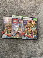 Photo of three Xbox 360 game cases: Kinect Adventures (two versions) and Lego Marvel Super Heroes.
