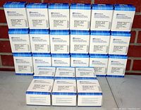 24 boxed Dataproducts black inkjet cartridges arranged in rows against a brick background and on a white surface