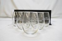 Six Ron Zacapa branded rum glass tumblers arranged in front of the black gift box.