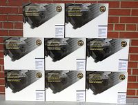 Photo showing eight boxed Lexmark black toner cartridges stacked against a brick wall.