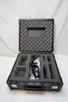 Open protective case showing foam-padded interior with multiple compartments designed for equipment storage.