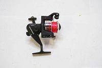 Side view of Johnson spinning reel showing model number S2000F and spool wrapped with red fishing line.