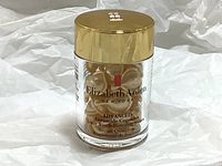 Front view of a clear plastic jar containing 30 golden capsules with a gold lid; product and brand name visible on the jar.