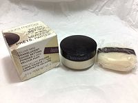 Box, jar with black lid, and sealed mini velour puff side by side on a white background.