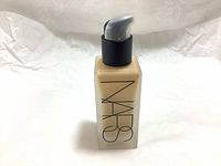 Front view of frosted glass bottle with black pump dispenser and NARS logo on front